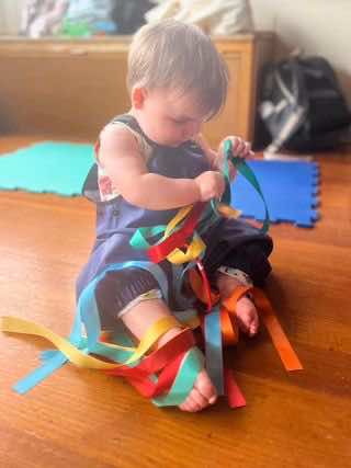 A baby plays with a sensory toy for International Dance Day