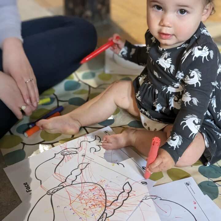 A happy child makes marks at a Little Learners class