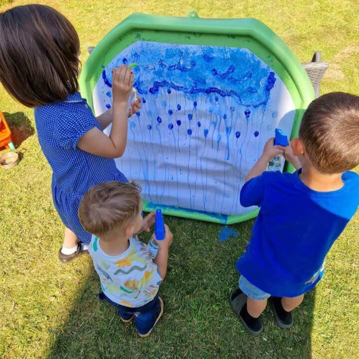 Some Little Learners create spray bottle art on a tuff tray