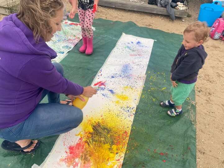 Anita from Little Learners South Colchester helps a child make spray bottle art