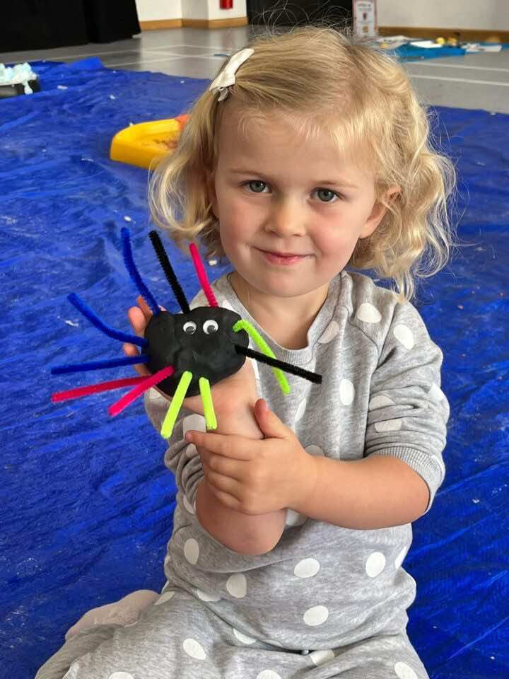 A child holds a playdough spider she has made in a Little Learners South Colchester class