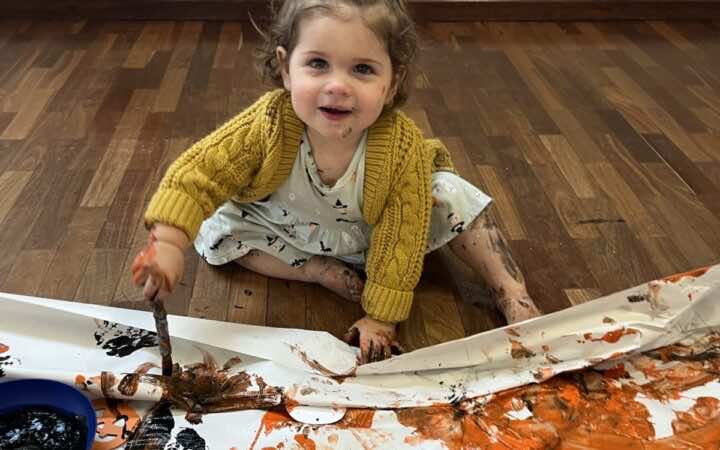 A child does some witch paintings at a halloween messy play class for Little Learners UK