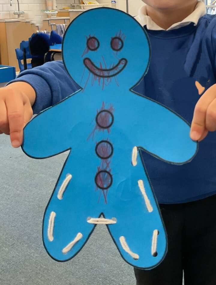 Gingerbread man with wool threaded around the edge of his body