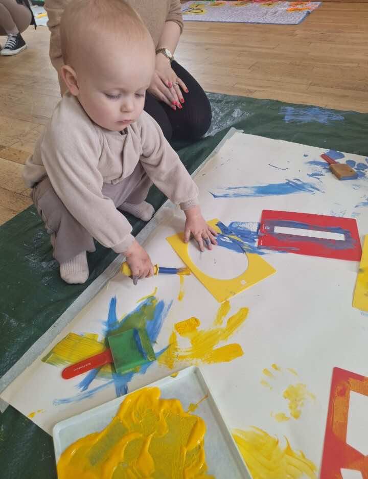 Toddler using a stencil to print